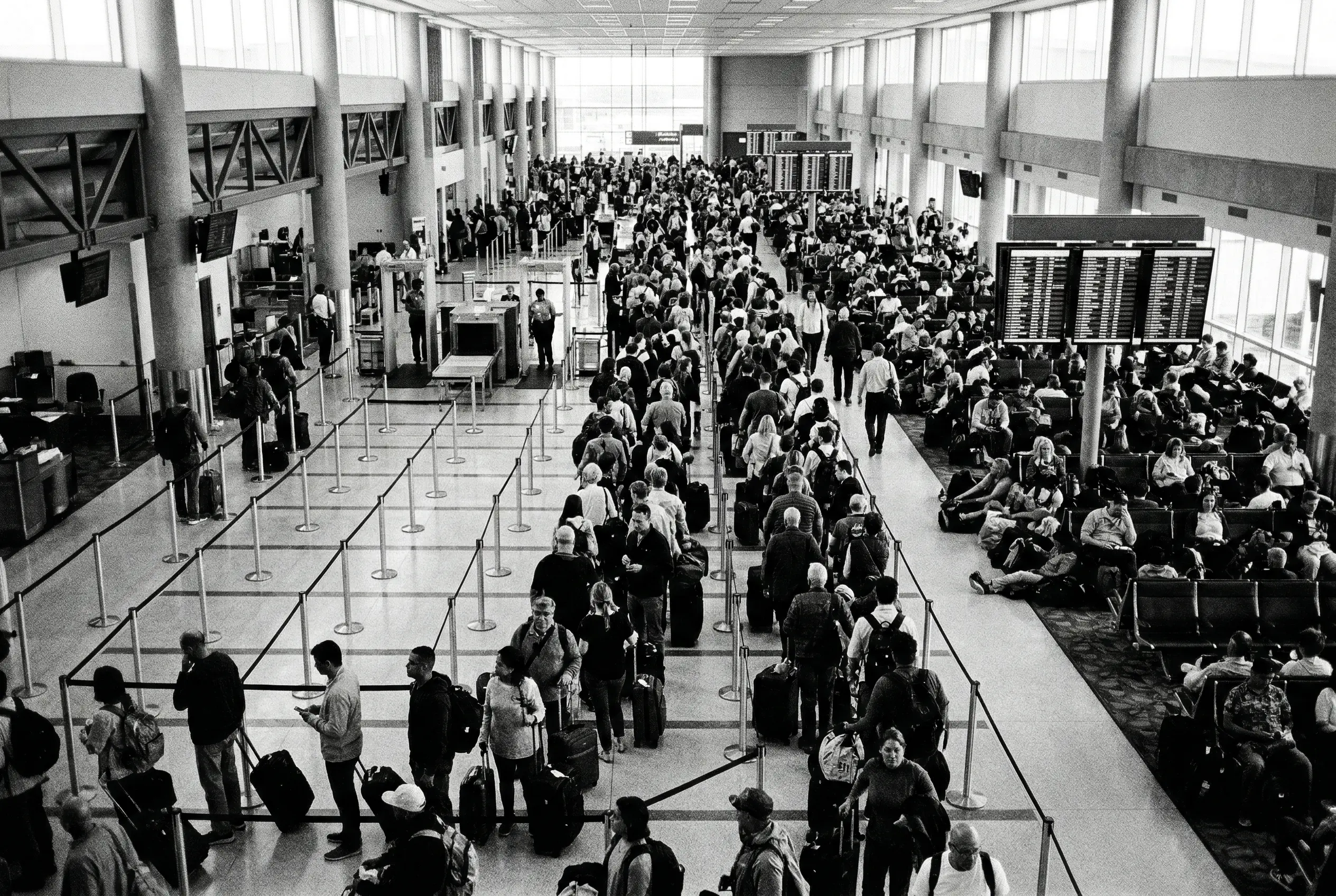 Crowded commercial airport terminal with long security queues and boarding delays